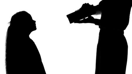 Silhouette Little girl giving a gift to her mother and kissing track matteの写真素材