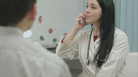 Doctor having an important phone call in medical officeの写真素材