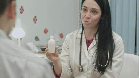 Smiling female doctor recommending drugs to patientの写真素材