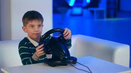 Concentrated little boy playing virtual reality racing gameの写真素材