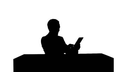 Silhouette Business man working on digital tablet on his table in his officeの写真素材