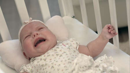 crying baby in bedの写真素材
