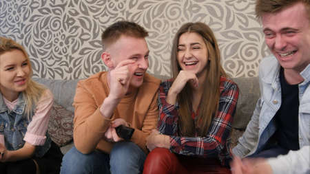 Best friends sitting on sofa, enjoying and discussing comedy movieの写真素材