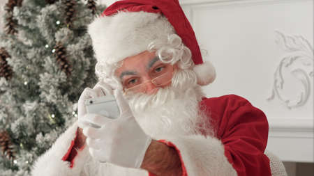 Santa Claus taking merry selfies on his phoneの写真素材