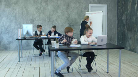 Little business kids working in office, using flipchart, discussing problemsの写真素材