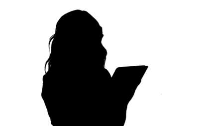 Silhouette Smiling young woman working on tablet computer track matteの写真素材