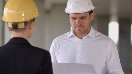 Business people man and woman discussing about building plan for construction at job siteの写真素材