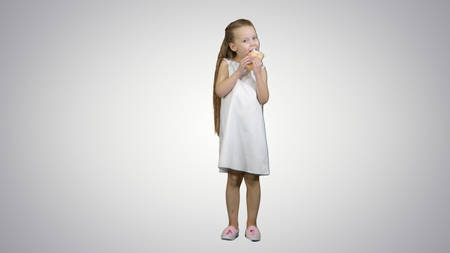 Kid girl eating ice cream on white backgroundの写真素材