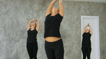 Group of young women finishing asana, practicing yogaの写真素材