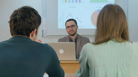 Pupils listening teacher in classroomの写真素材