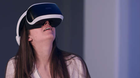 Smiling woman in virtual reality headset enjoying her experienceの写真素材