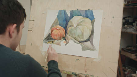 Young male student painting watercolor still lifeの写真素材