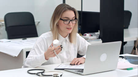 Female medicine doctor prescribing medicine using laptopの写真素材