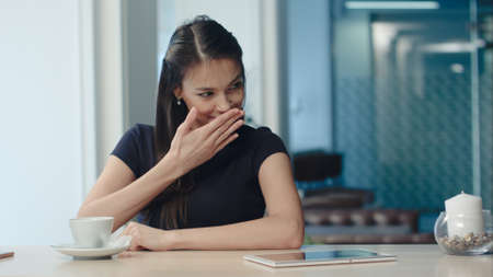 Pretty young woman drinking tea and flirting in a coffee houseの写真素材