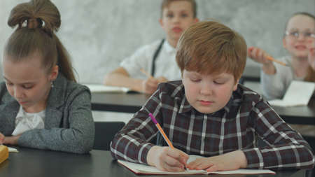 Pupils writing down information in exercise books dusring lessonの写真素材