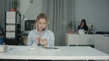 Pretty call operator taking selfie and sending it by phoneの写真素材