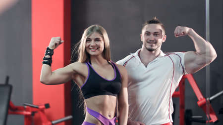 Sporty young couple posing and showing off their bicepsの写真素材