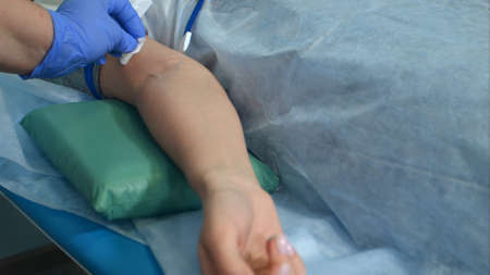 Nurse putting intravenous injection on patient arm for drip medicine