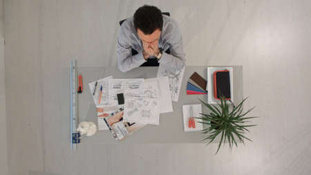 Desperate businessman in his office looking down. Top viewの写真素材