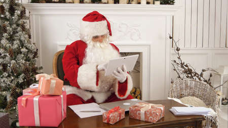 Santa Claus using tablet to give a quick video call to the North Poleの写真素材