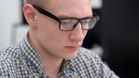Young man in glasses working in the officeの写真素材