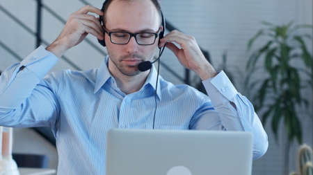 Young man working in a call centreの写真素材