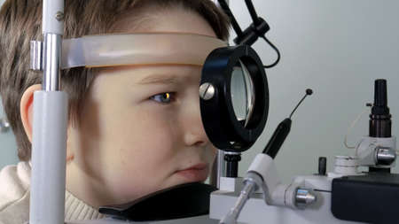 Optometrist performing visual field test of young boy