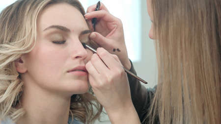 Make-up artist applying eyelash makeup to model eyeの写真素材