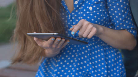 Woman using digital tablet in the park.の写真素材