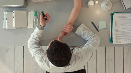 Top view of The doctor measures pulse at the patientの写真素材