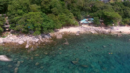 Copter fly up from stony beach with peopleの写真素材