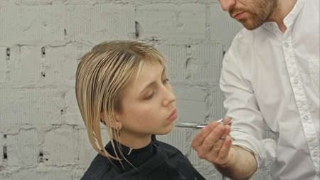 Young beautiful woman having her hair cut at the hairdressers.の写真素材
