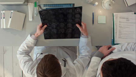 Doctors  team having a discussion and review a magnetic resonance imaging. Top viewの写真素材