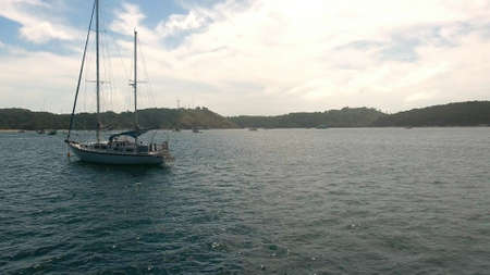 Copter fly over the yacht moored in a bay near rockの写真素材