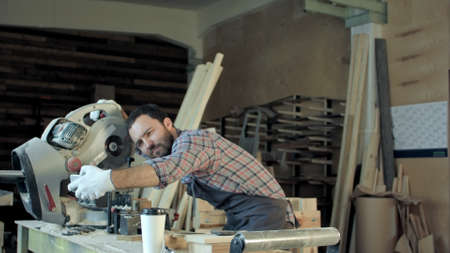 Smiling workman with beard makes a selfie using his smart phone.の写真素材