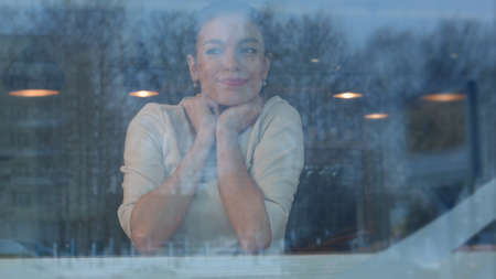 Young woman waiting in cafe for her order to be brought by the waiterの写真素材
