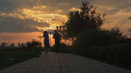 Young couple walking in sunset. Slide.の写真素材
