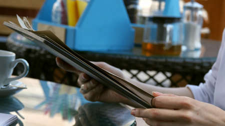 Young woman looking at the menu in a restaurantの写真素材