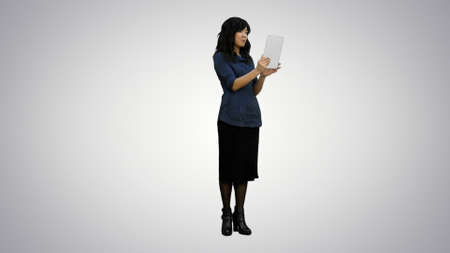 Asian lady having video chat using a tablet on white backgroundの写真素材