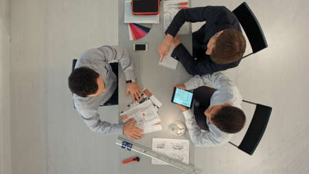 Team of architects working on construction plans. Top viewの写真素材