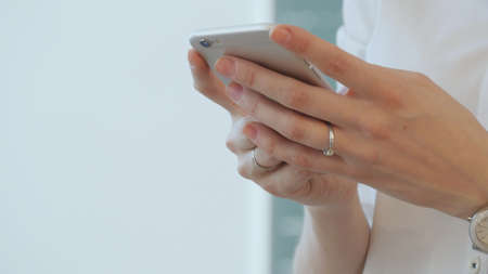 Young female teacher writes an SMS to your mobile phone.の写真素材