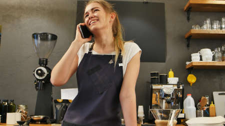 Young female calling using cell phone at work placeの写真素材