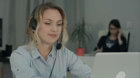Young female worker making video call via laptop in the officeの写真素材