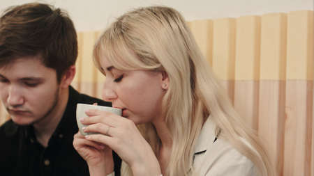 Portrait of young couple talking seriously and drinking coffee at a coffee shop