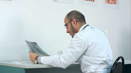 Young male doctor examining chest xray imageの写真素材