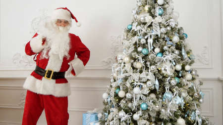 Santa Claus doing funny robot dance next to the Christmas tree
