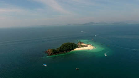 Aerial view, camera flies around thewild island in the sea at sunny summer dayの写真素材