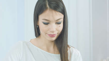 Pretty young woman inserting white earphones into her ears to listen to the musicの写真素材