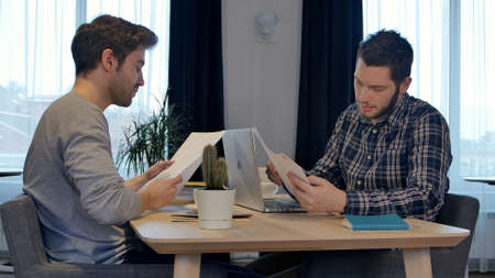 Business partners shaking hands in the office, finishing work with documents