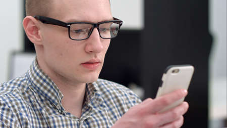 Serious office worker using mobile phoneの写真素材